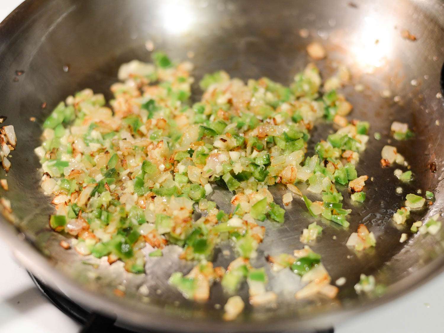Finely diced onion and jalapeno sauteing for beef taco filling.