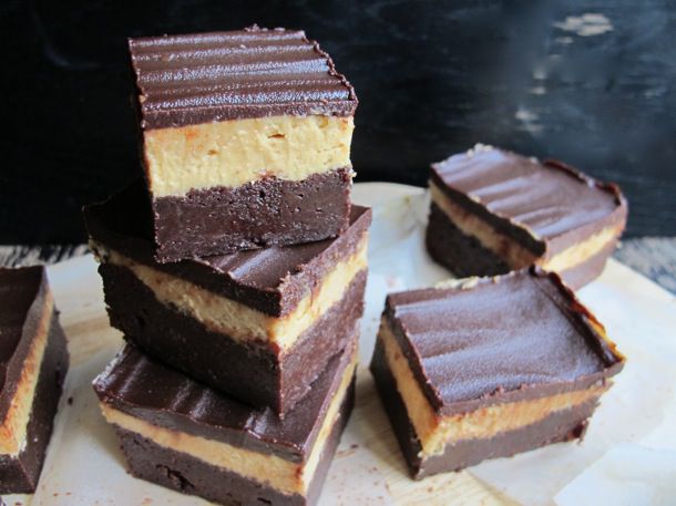 A stack of 3-layered peanut butter brownies topped with chocolate.
