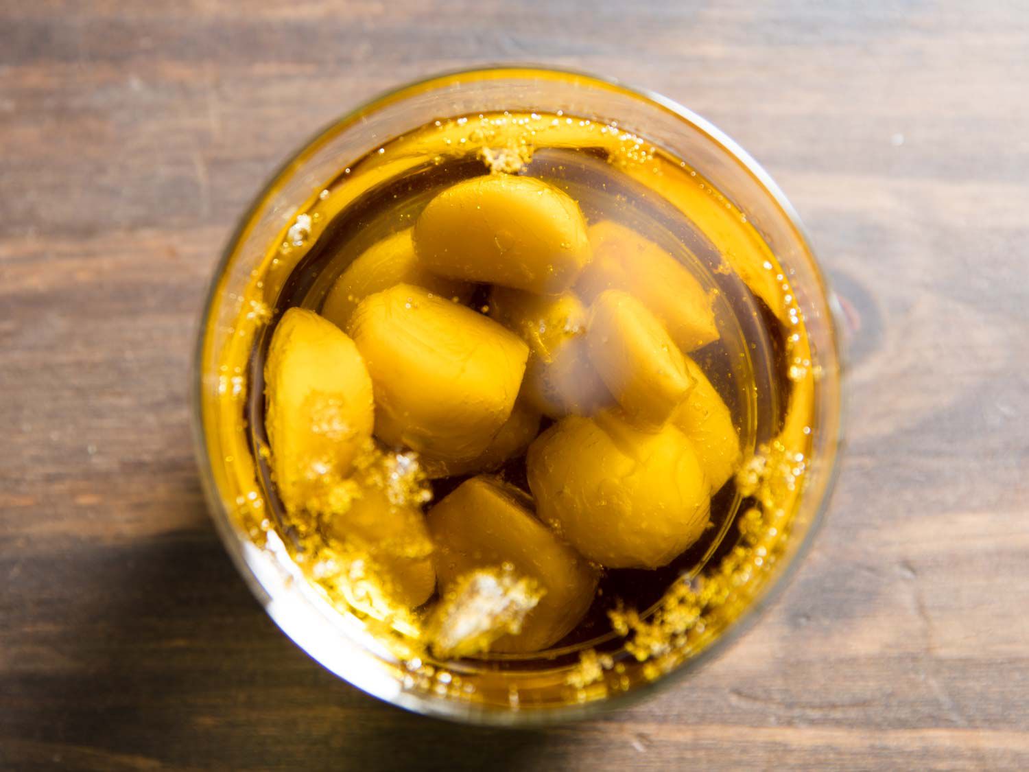 Top down view of a jar of homemade garlic confit. 