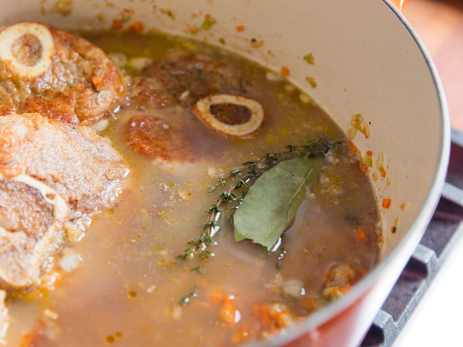 Osso buco simmering in a Dutch oven.