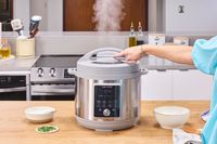 A person presses a button on the lid of the Instant Pot Duo Plus 8 Quart Multi-Use Pressure Cooker