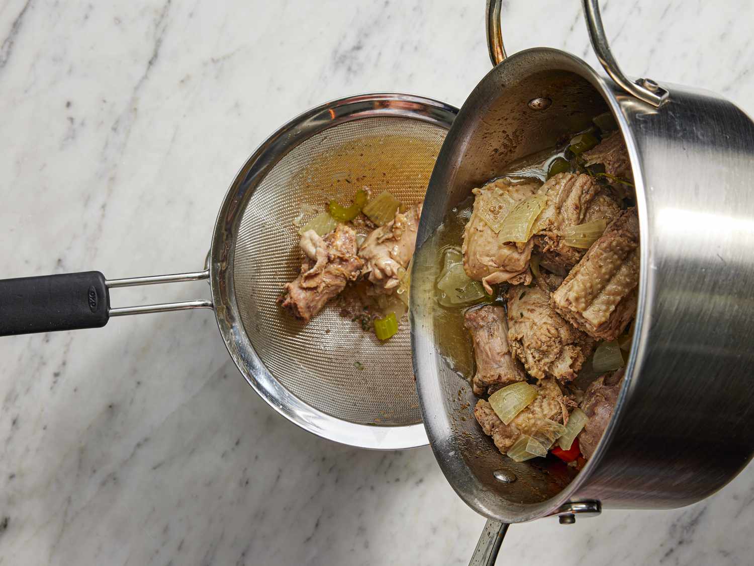 Straining broth through a fine mesh strainer