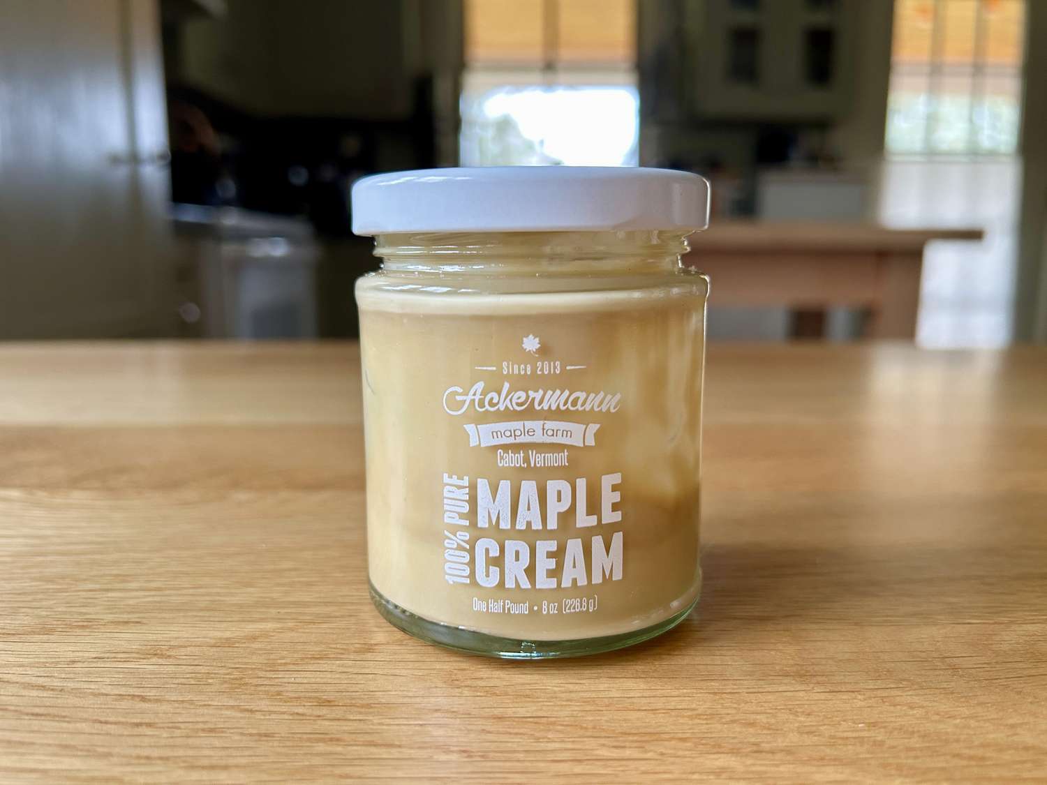 A small jar of maple cream on a kitchen table