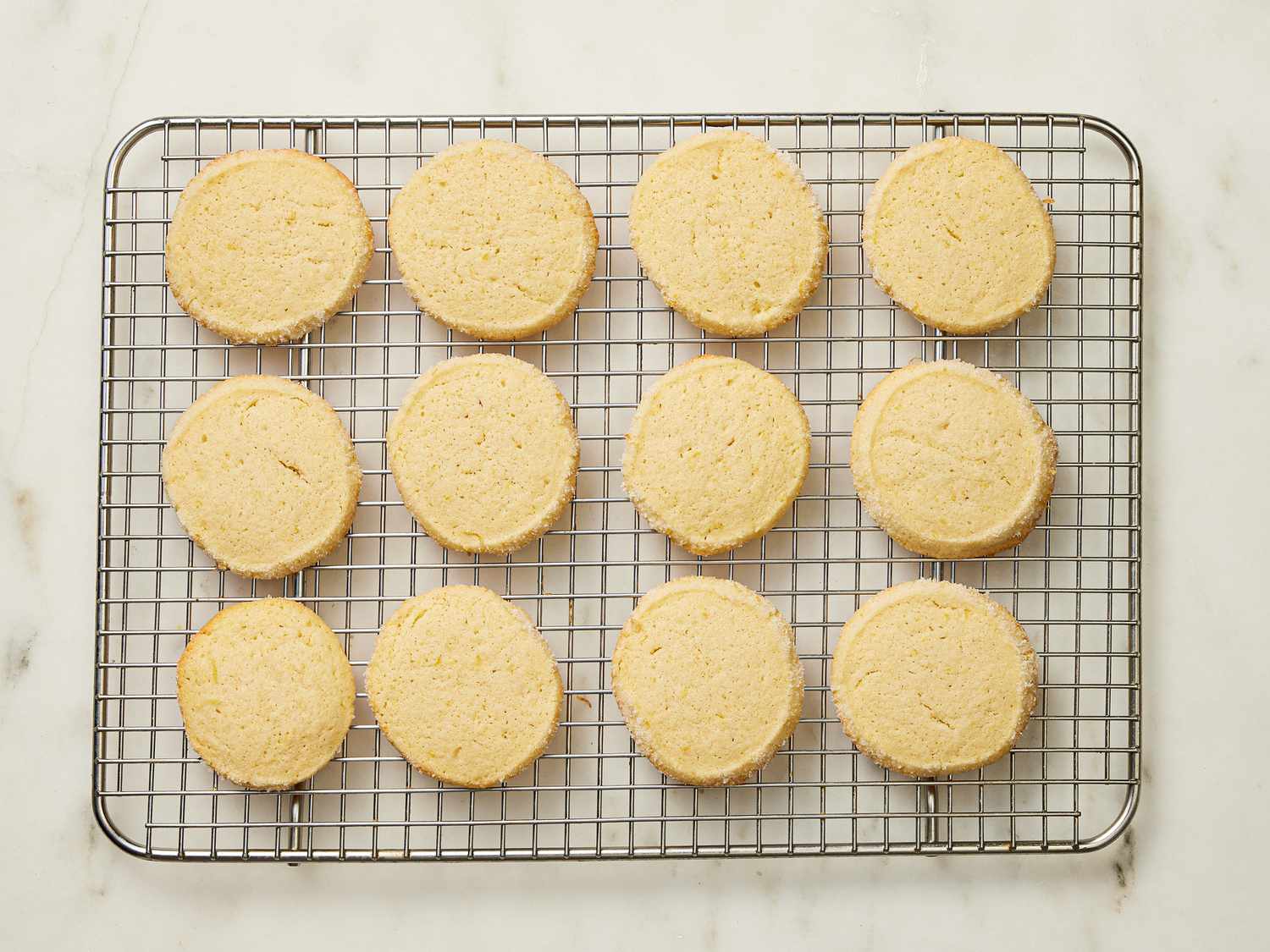 baked cookies cooling on a metal rack, on a white marble surface 