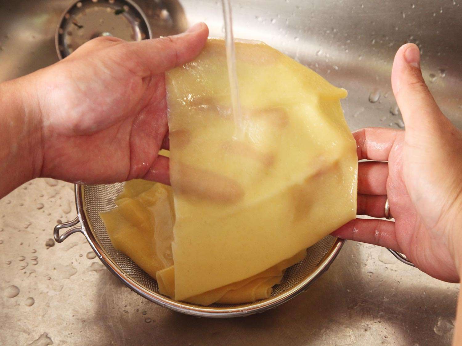 Running freshly cooked pasta under cold water