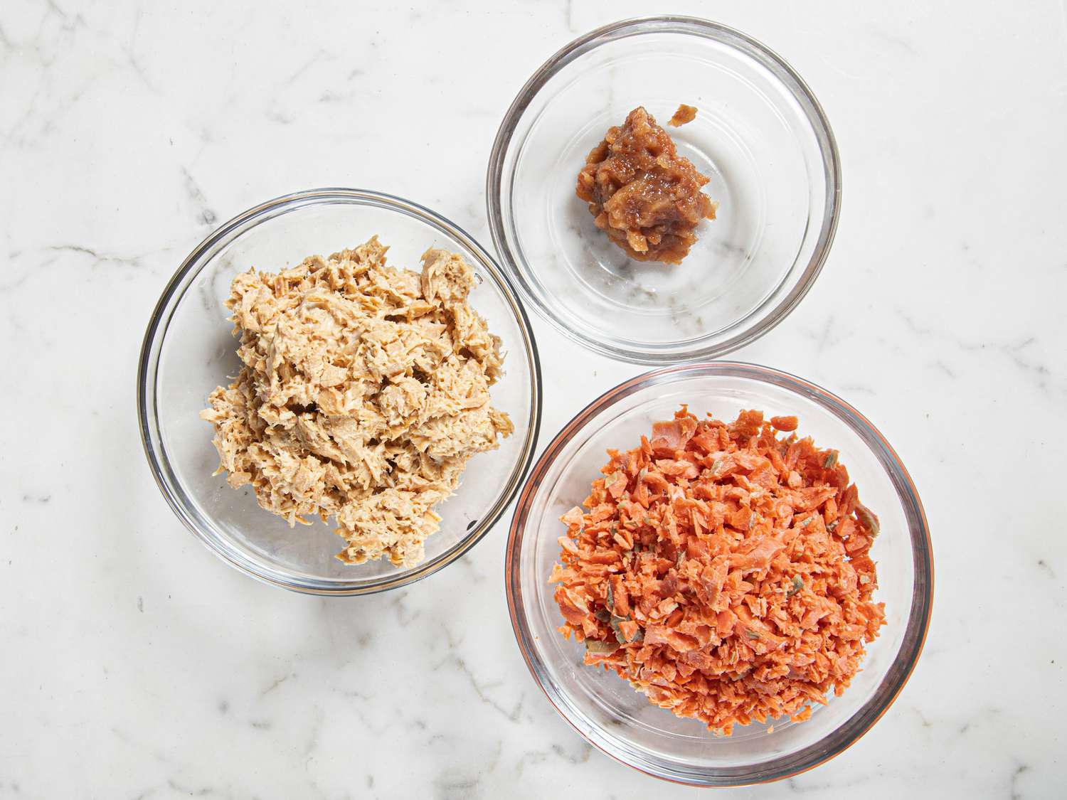 Three filling options for onigiri (plum, salmon and tuna) in a set of bowls