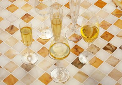 a variety of champagne glasses on a marble tile surface