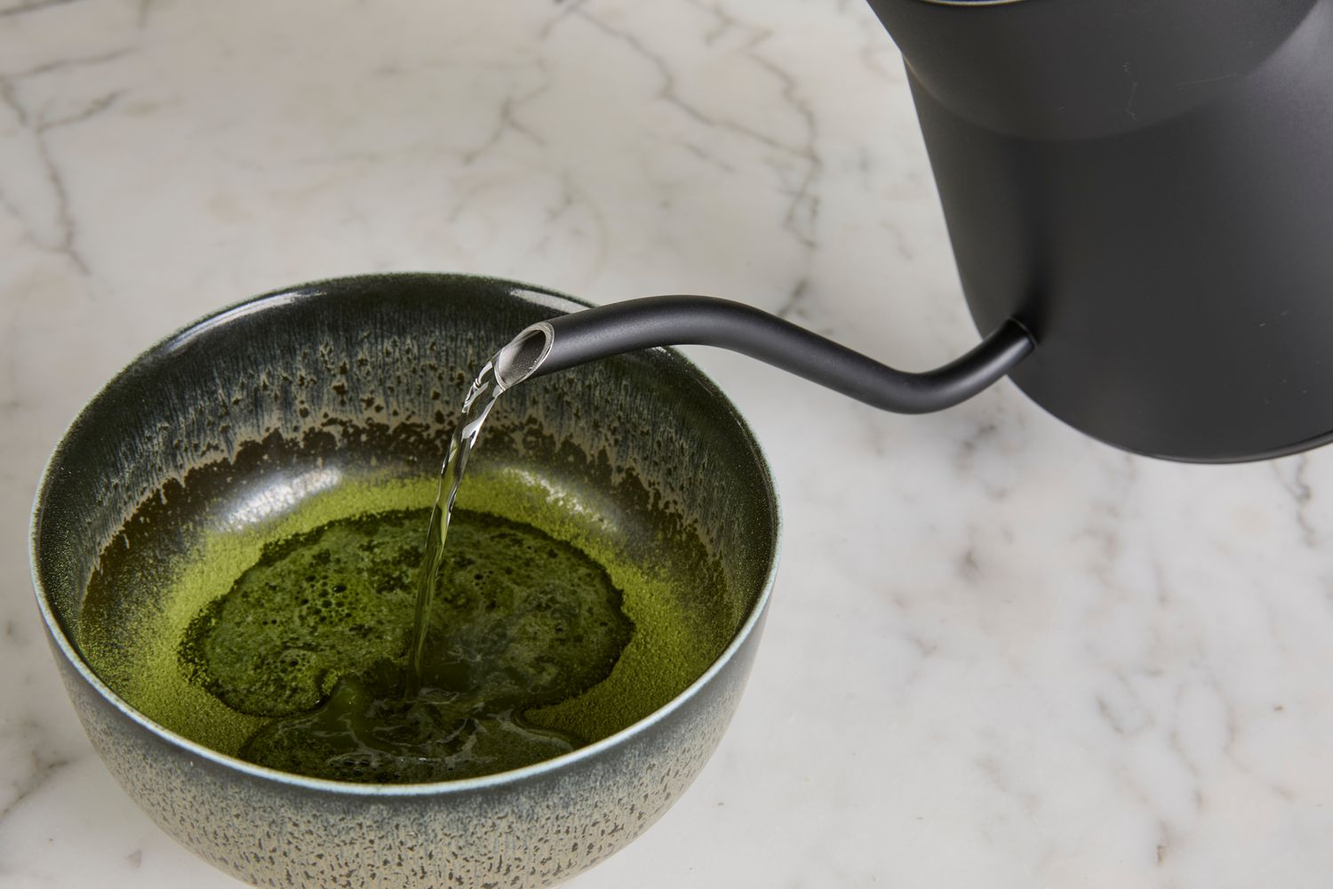 Water being poured from Saki Baristan Electric Gooseneck Kettle into a bowl with matcha.