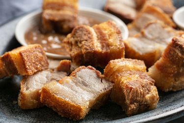 A close up of lechon kawali (Filipino crispy pork belly) on a plate.