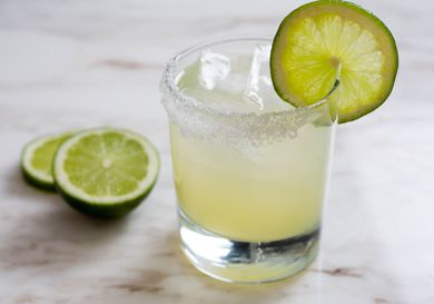 Classic margarita in rocks glass with lime wheel on salted rim