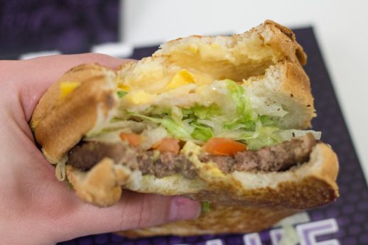 A Stacked Grilled Cheese Burger with a few bites taken out of it.