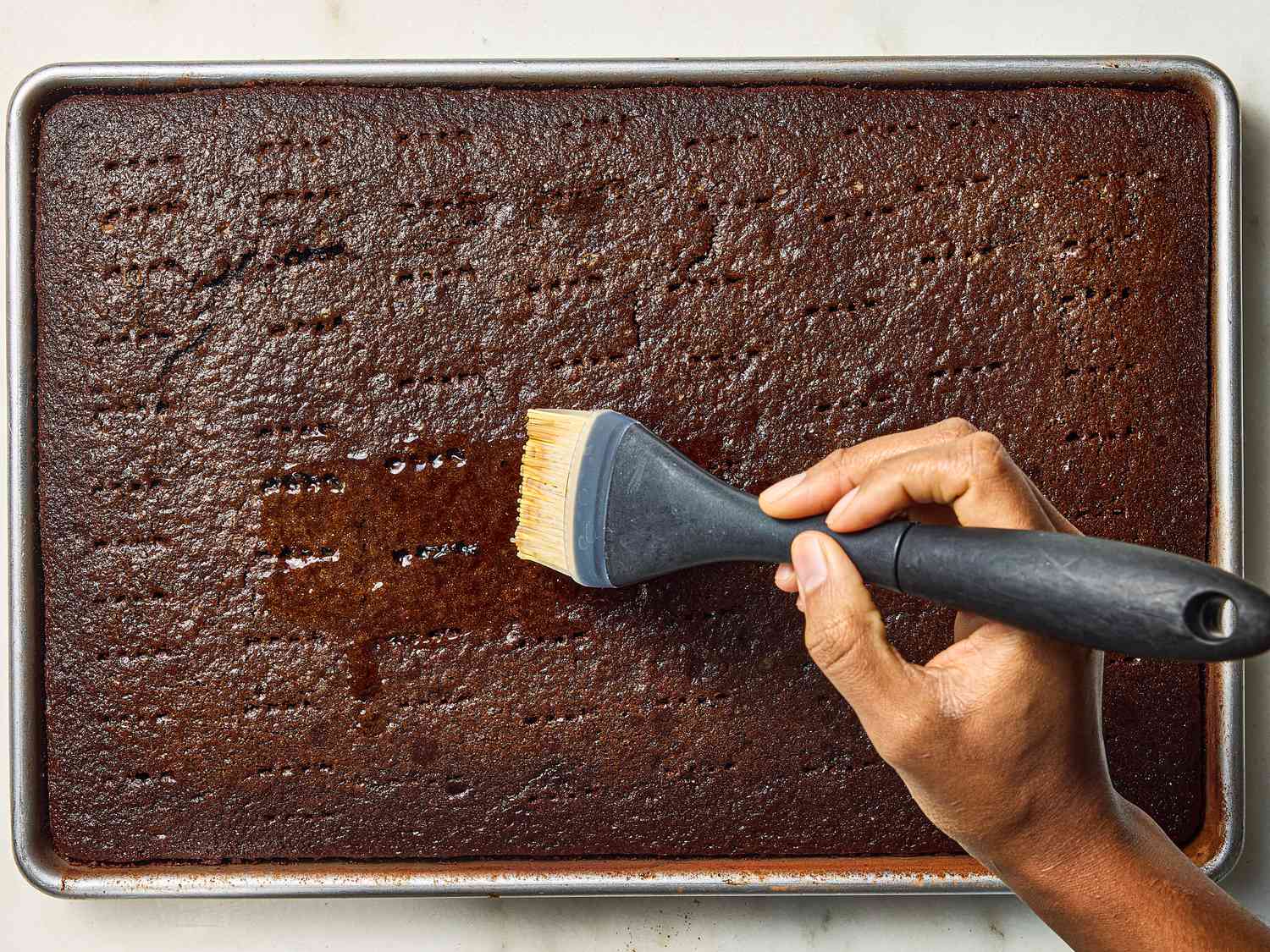 brushing chocolate cake with beer syrup