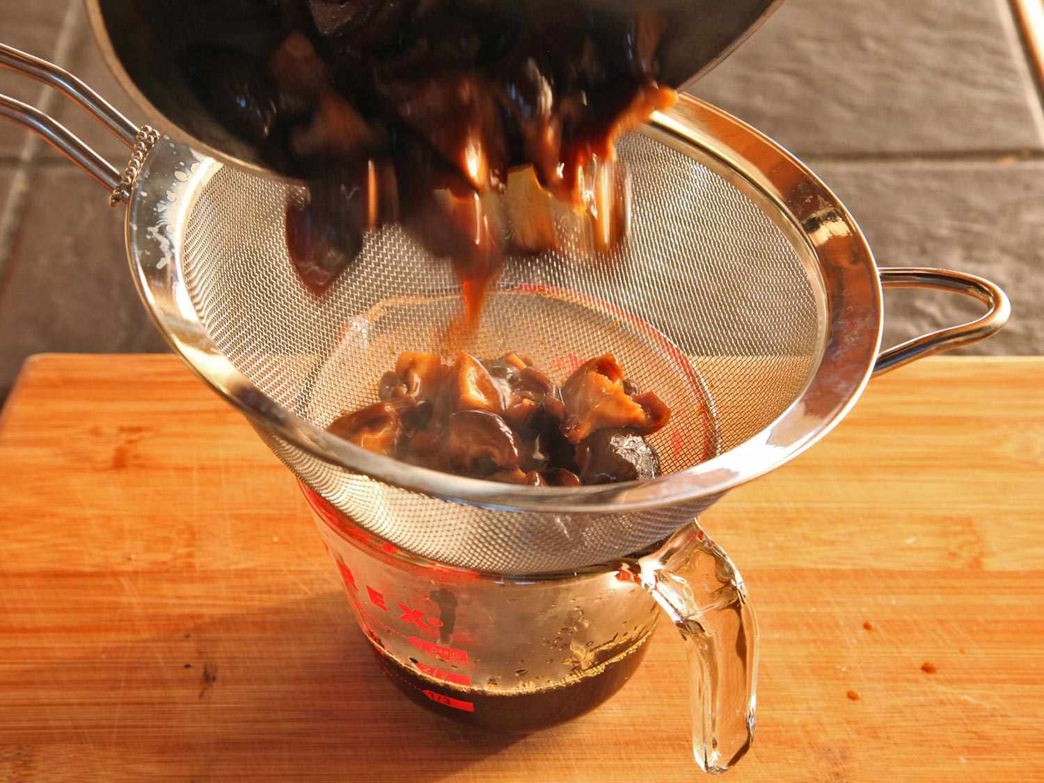 Draining soaked mushrooms for vegan ramen.