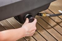 A close-up of a hand turning a nob on the Ooni Koda 16 Gas Pizza Oven