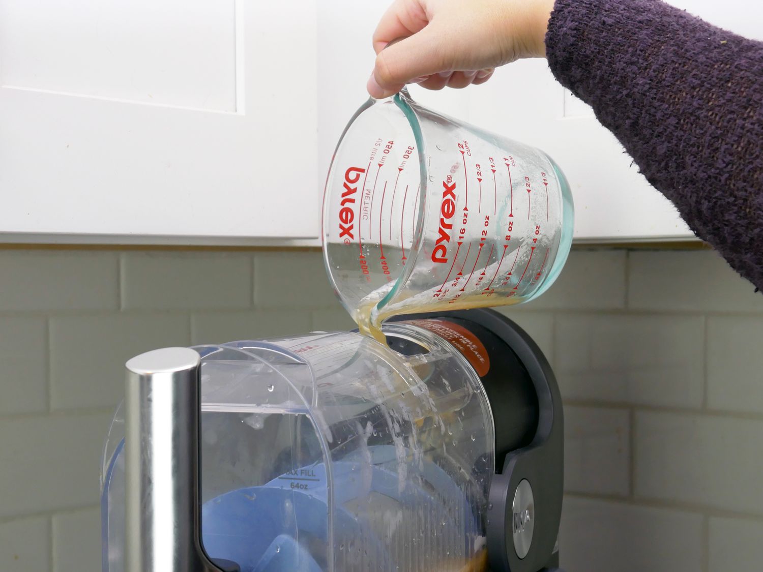 pouring liquid into the top of the ninja slushi