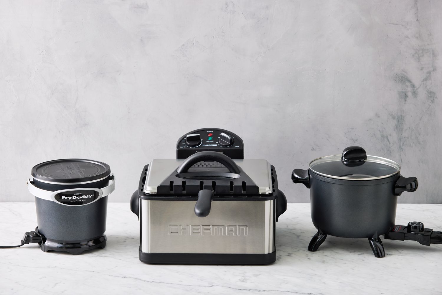 three electric deep fryers on a marble surface