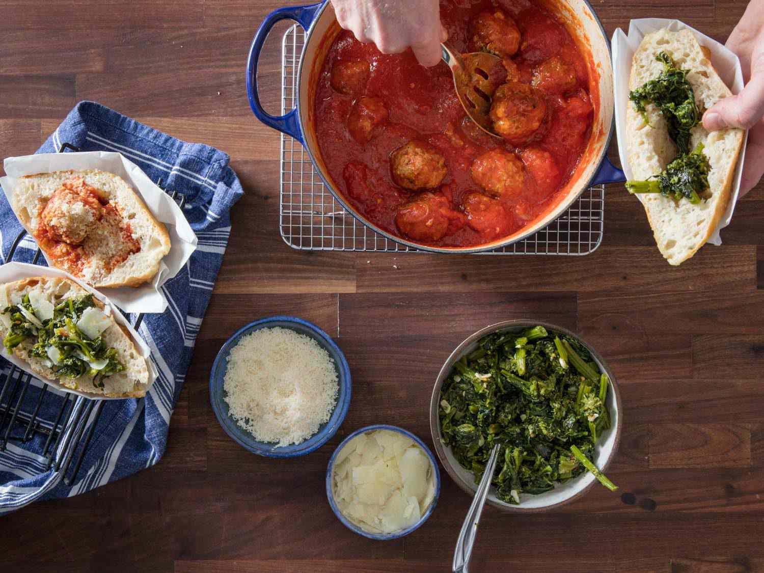 Action overhead shot of filling a trapizzino with broccoli rabe and meatballs.