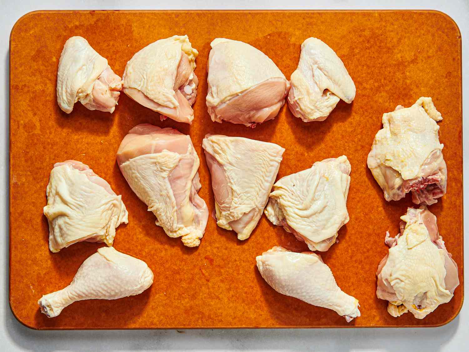 pieced out raw chicken on a cutting board 