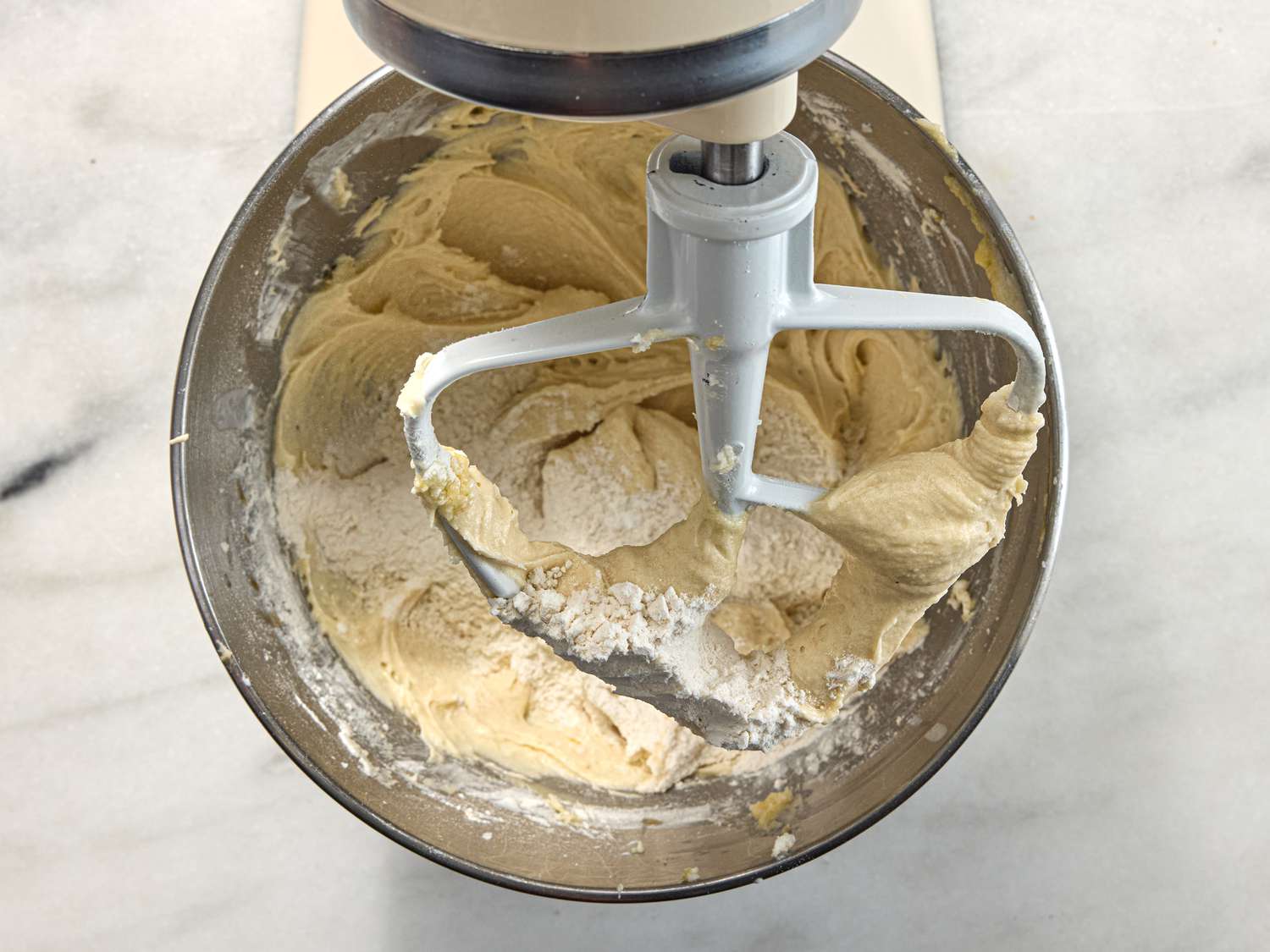adding flour to cake mixture in standing mixer 