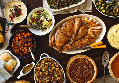 Traditional Thanksgiving dinner with roasted turkey stuffing mashed potatoes green beans and assorted side dishes and desserts