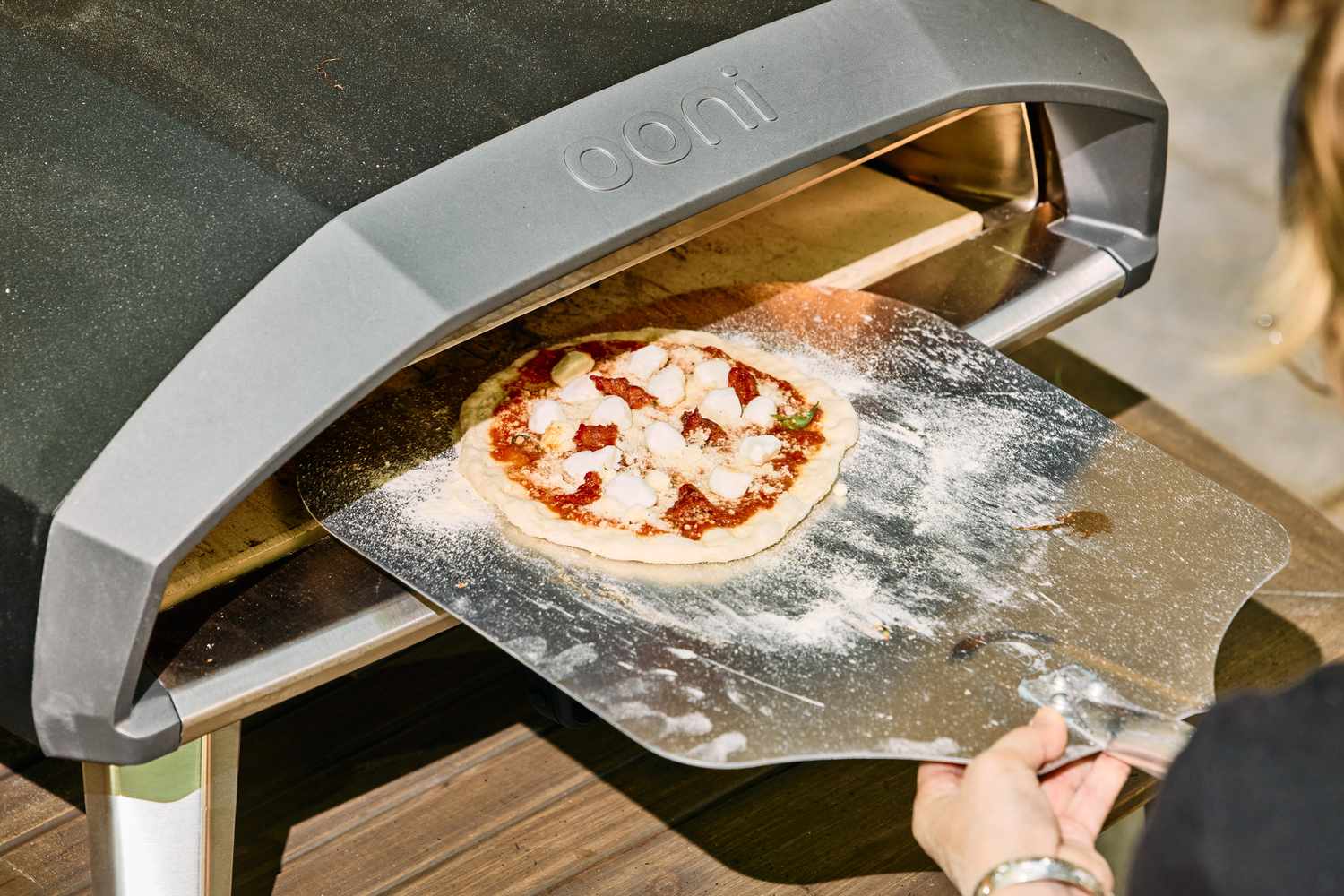 A pizza is placed into the Ooni Koda 2 Pro Gas-Powered Pizza Oven