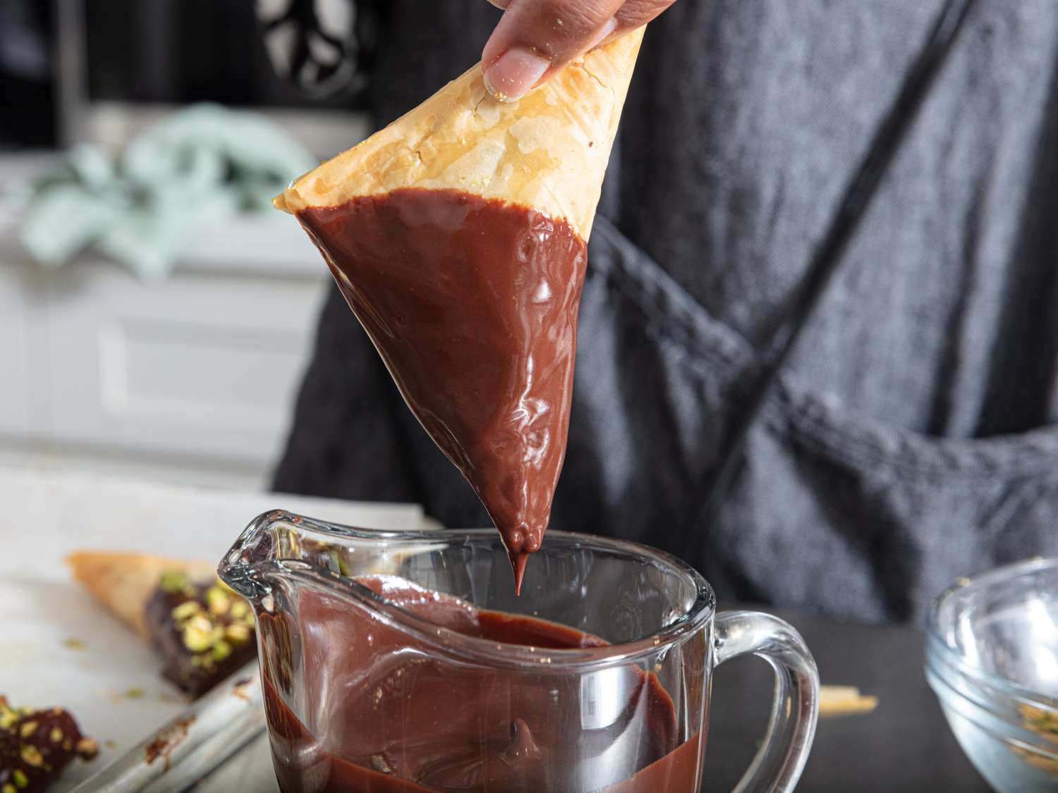 dipping triangle into chocolate in measuring cup