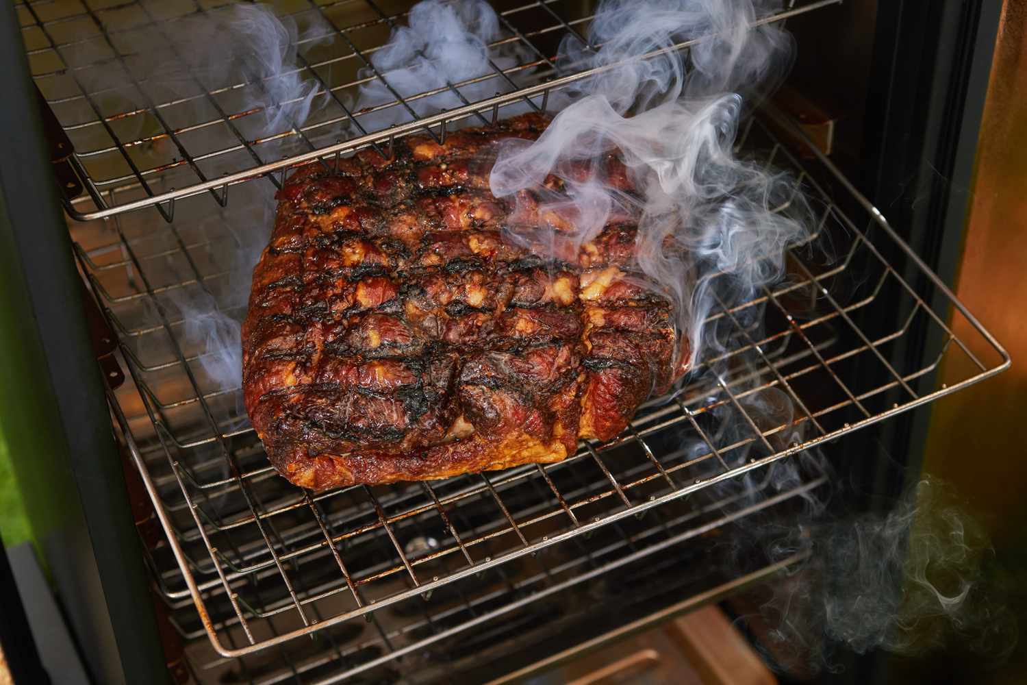 Ribs smoking on the rack of an electric smoker
