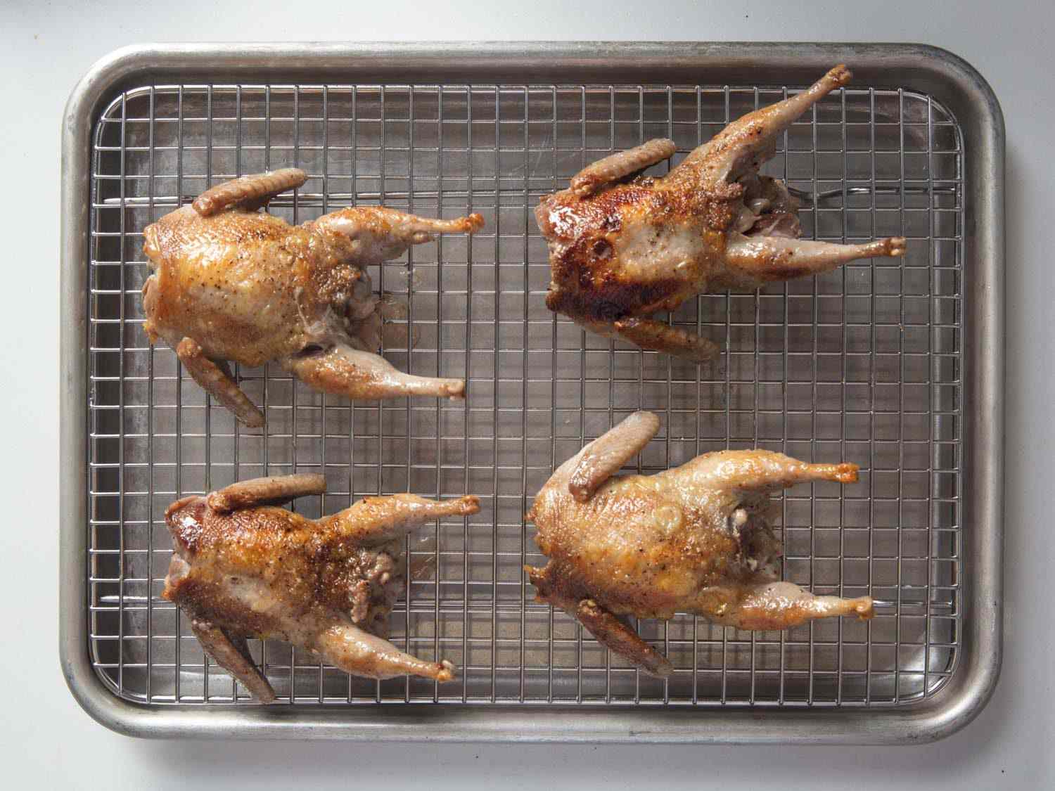 Cooked quail resting on sheet tray