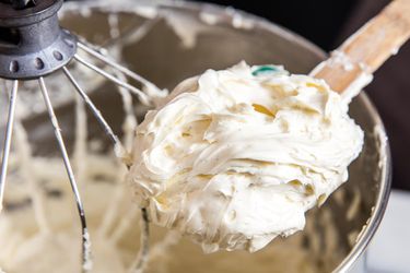 A wooden spoon mounded with buttercream.