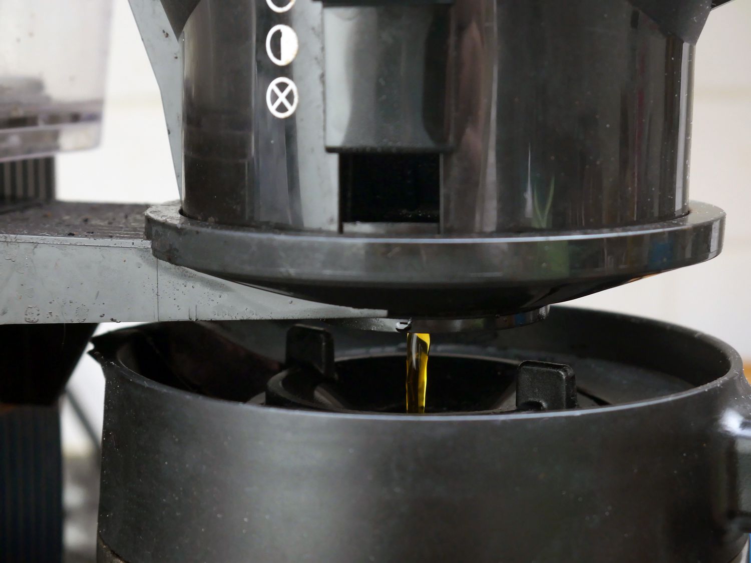 A closeup of the brewed coffee flowing from the basket into the carafe. 