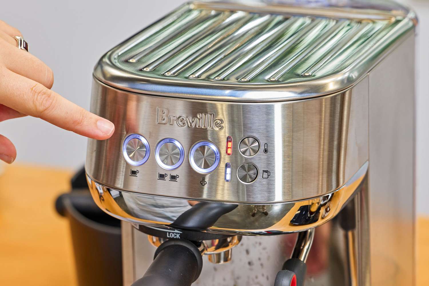 A person pointing to the display on the Breville Bambino Plus.