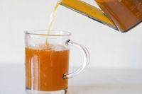 Liquid being poured from a container into a glass measuring cup