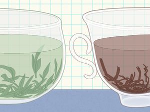 Two glass cups side by side one containing green tea leaves the other black tea leaves with a checkered background