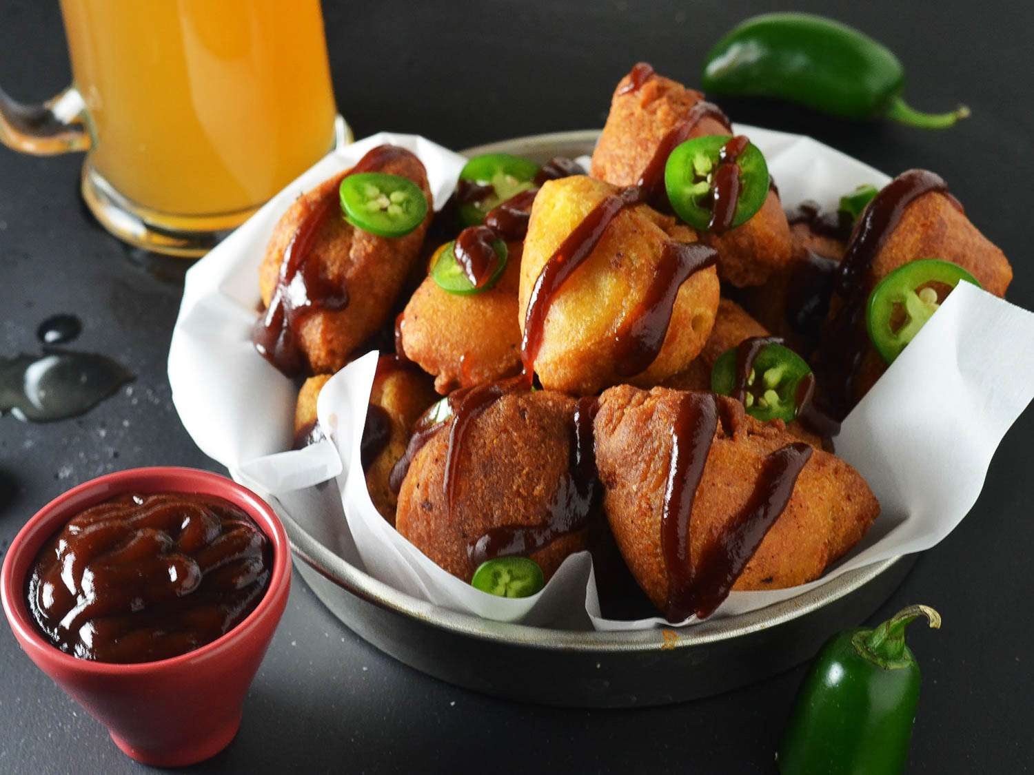 Fried wedges of cornbread-coated mac 'n cheese pulled pork topped with barbecue sauce and sliced green chile pepper.