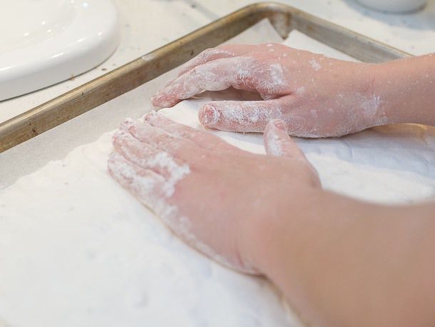 The kneaded nougat is stretched and shaped to fit over the two pieces of edible wafer paper.