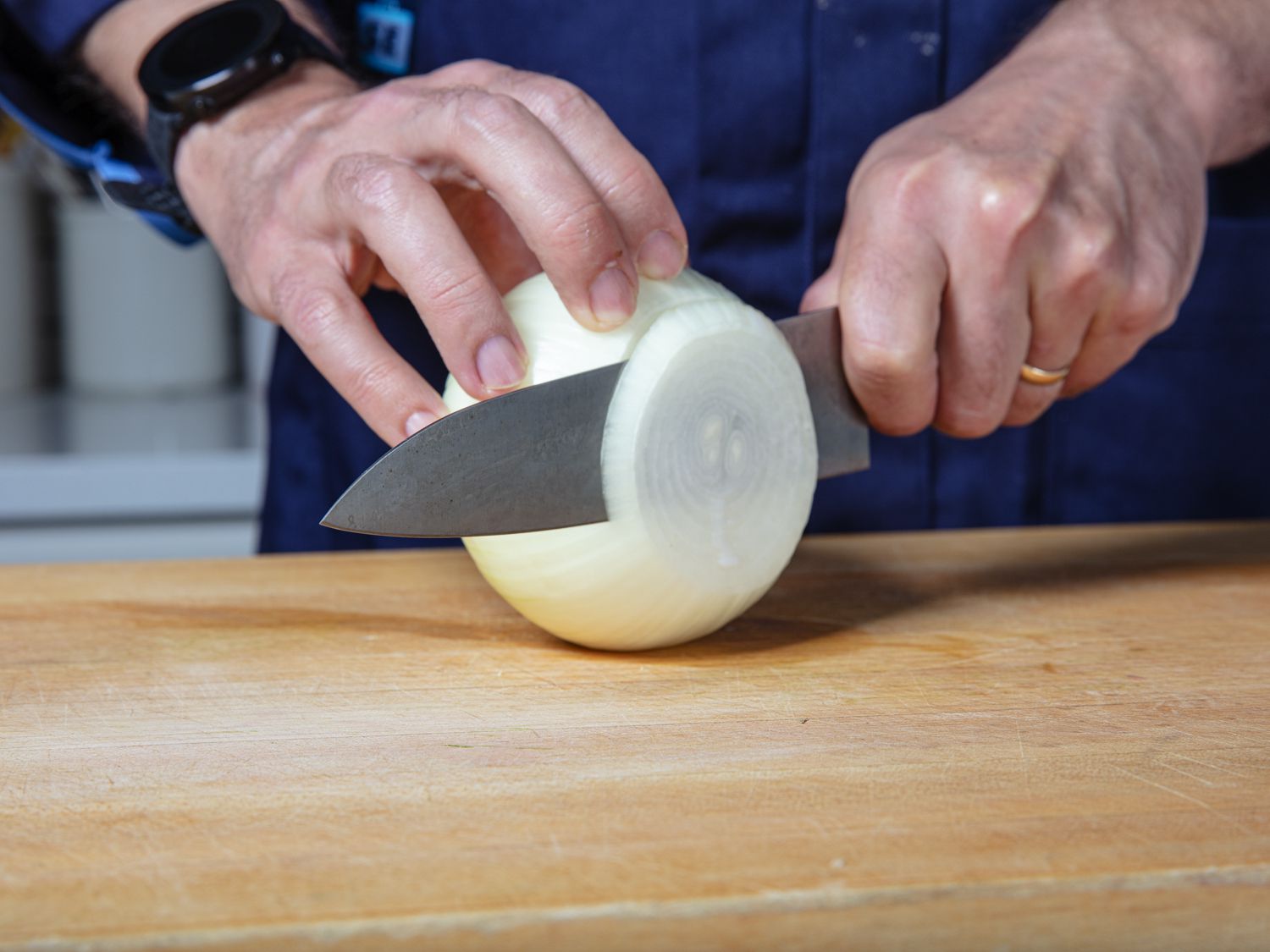 Slicing rings off a whole onion.
