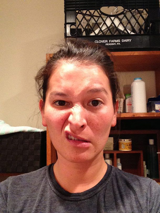 A photo of a woman in a gray T-shirt, with a sneer on her face