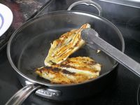 flipping chicken in a saute pan