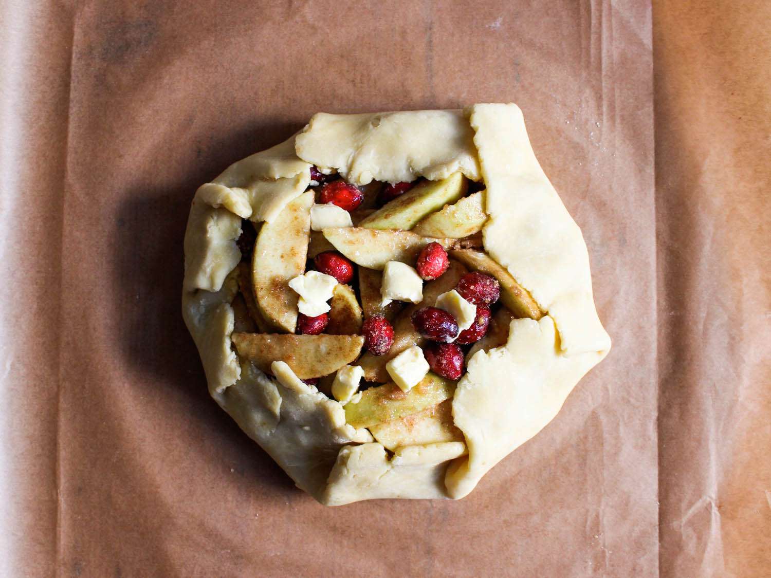 The outer margin of dough has been folded and made to overlap so that it partially encases the fruit filling.
