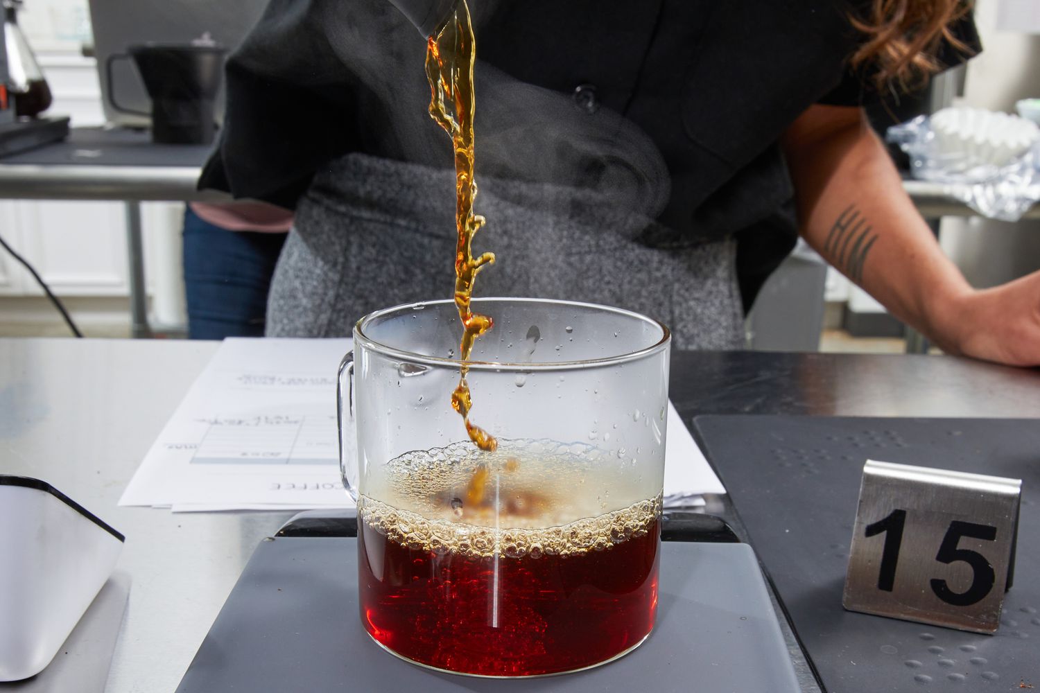 Coffee being poured into a glass mug on a scale