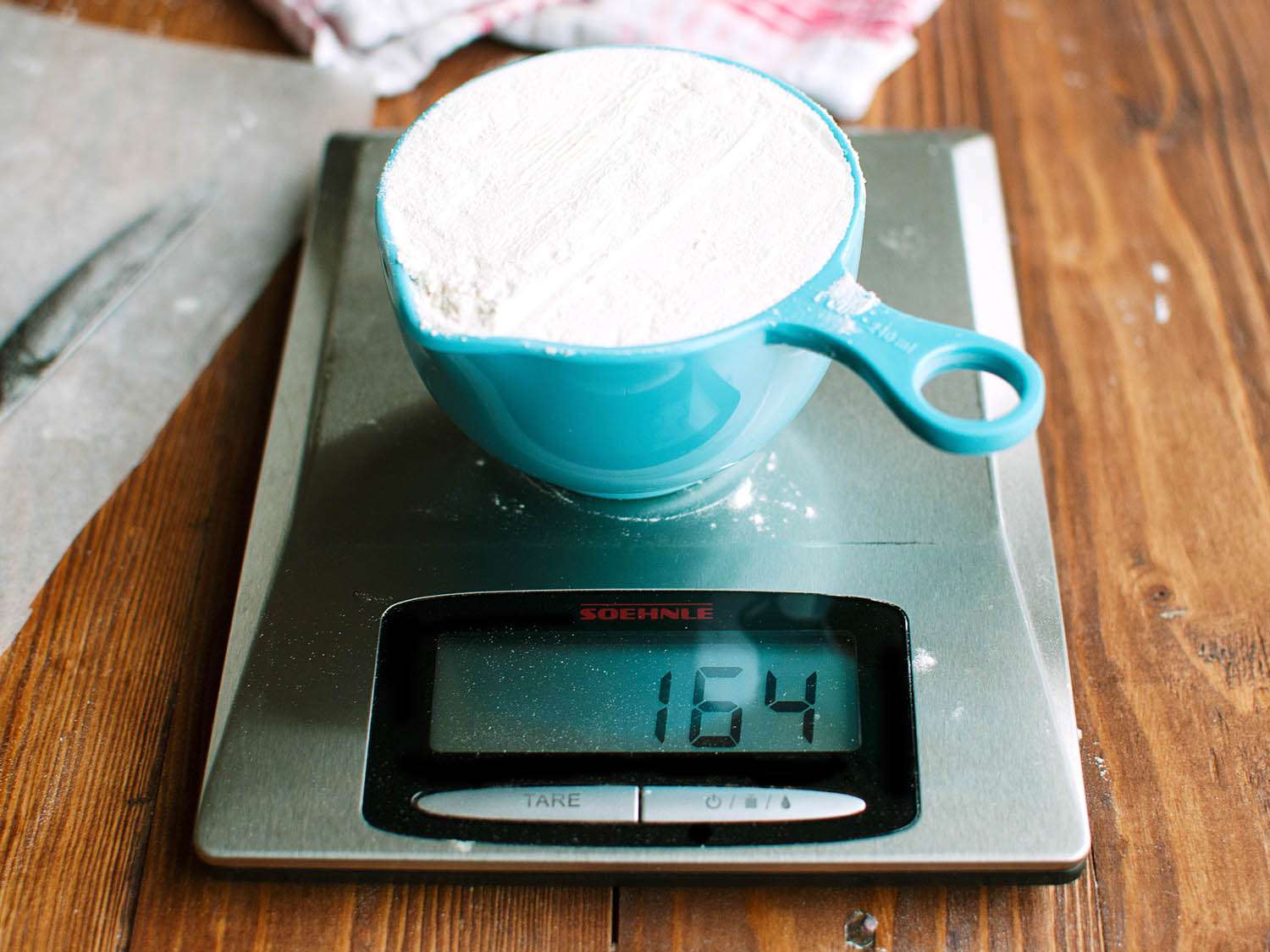 A firmly scooped cup of flour weighs 164 grams.