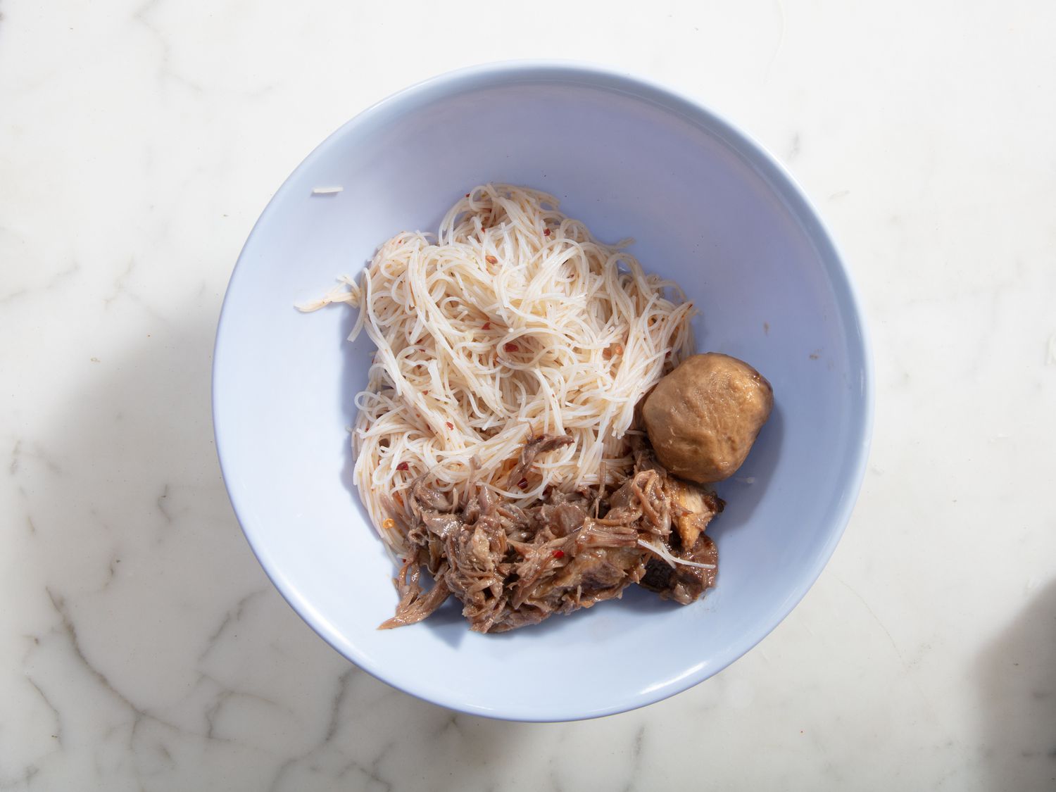 Overhead view of bowl with meat added