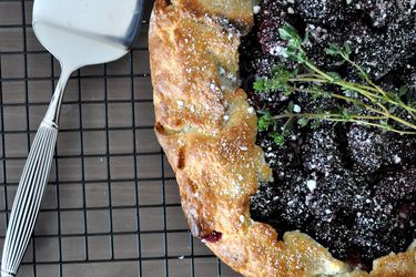 Overhead closeup of a blackberry thyme galette, cooling on a rack.