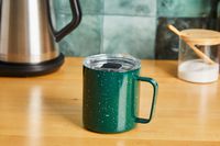 A green MiiR camp cup on a kitchen countertop.