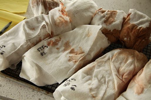 Steaks wrapped in paper towel with numbers written in Sharpie.