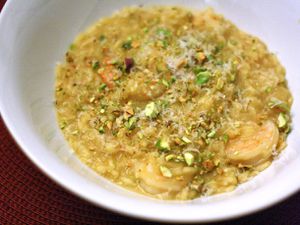 Closeup of Saffron Risotto with Shrimp and Pistachios, served in a plain old white bowl.