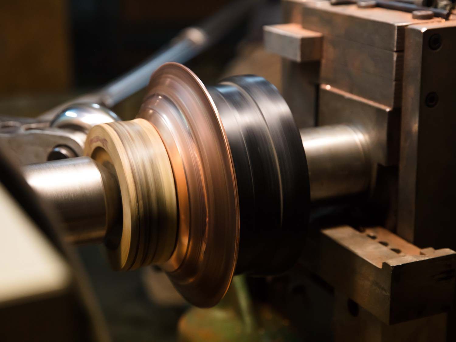 A disc of copper being spun into a saucepan on a lathe.