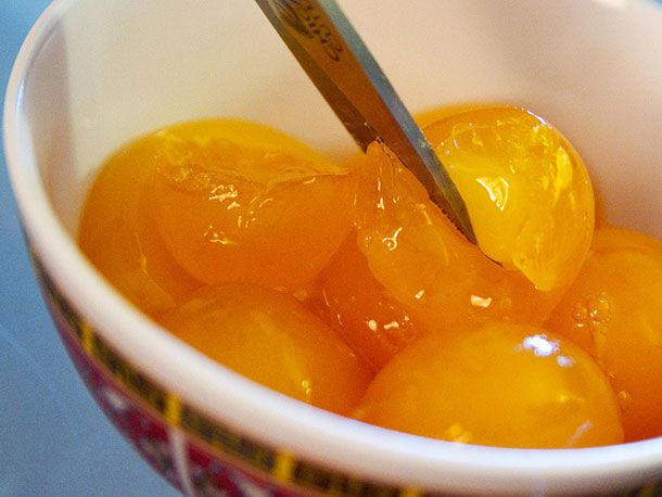 Kitchen shears cutting salted egg yolks. 