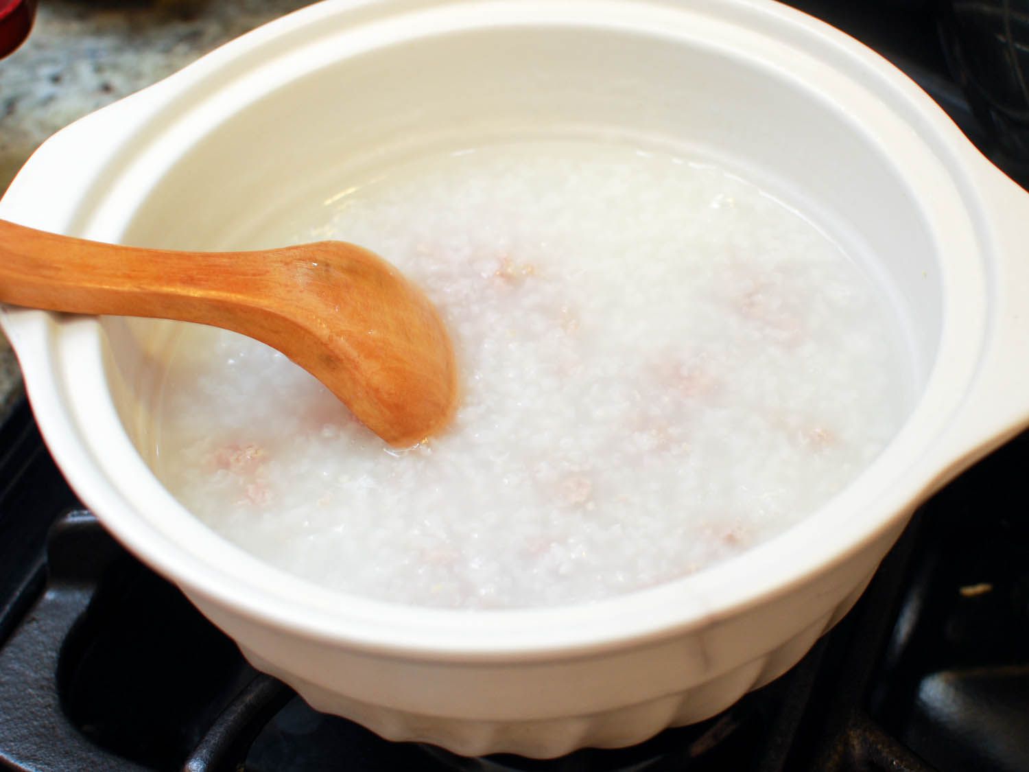 Adding pork to congee. 