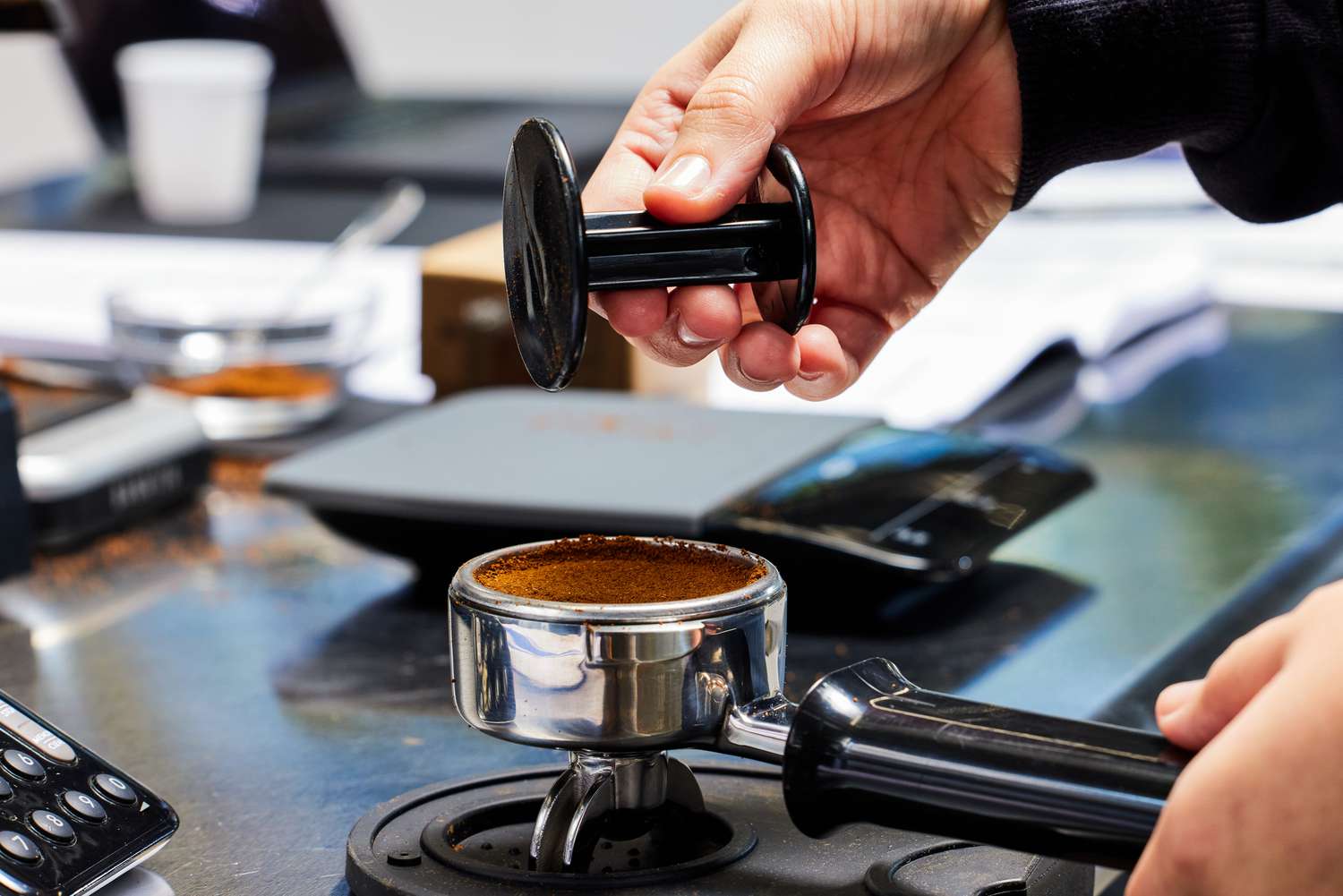 A person lifting up the portafilter part of the Gaggia Classic Pro Espresso Machine